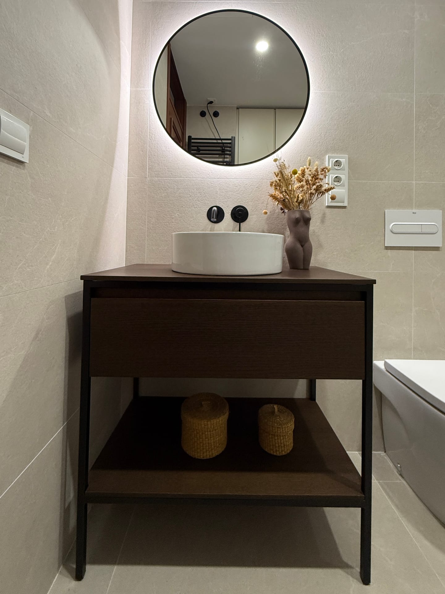 Mueble de lavabo con estructura metálica negra y lavabo redondo