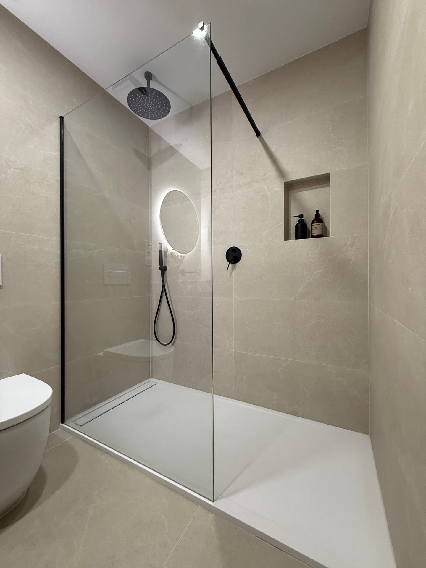 Ducha a ras de suelo con rociador de lluvia, espejo retroiluminado y hornacina