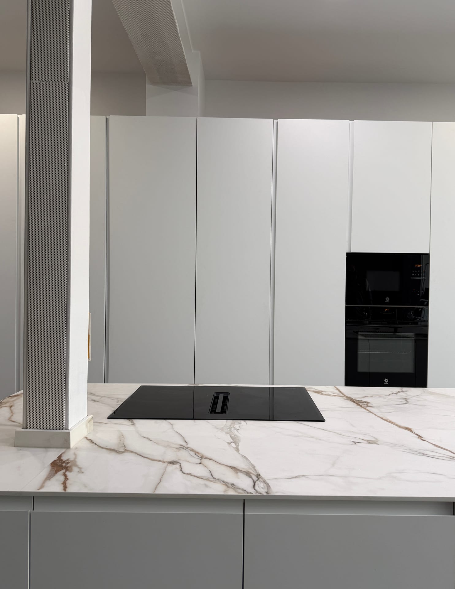 Encimera de Calacatta Gold con placa de inducción y extractor integrado