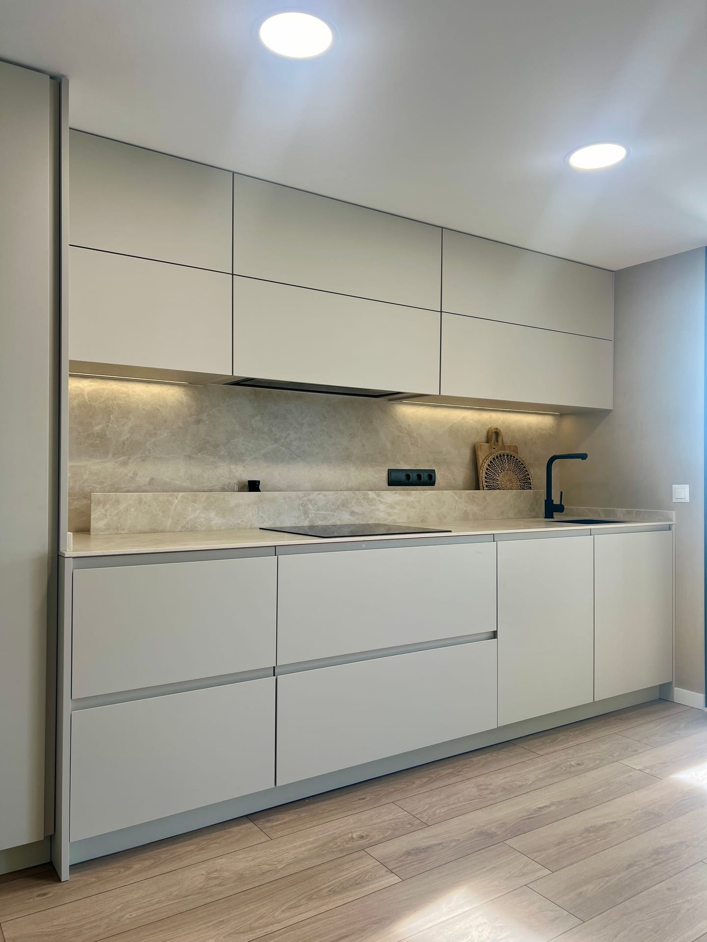 Cocina en tono neutro con iluminación bajo los muebles altos