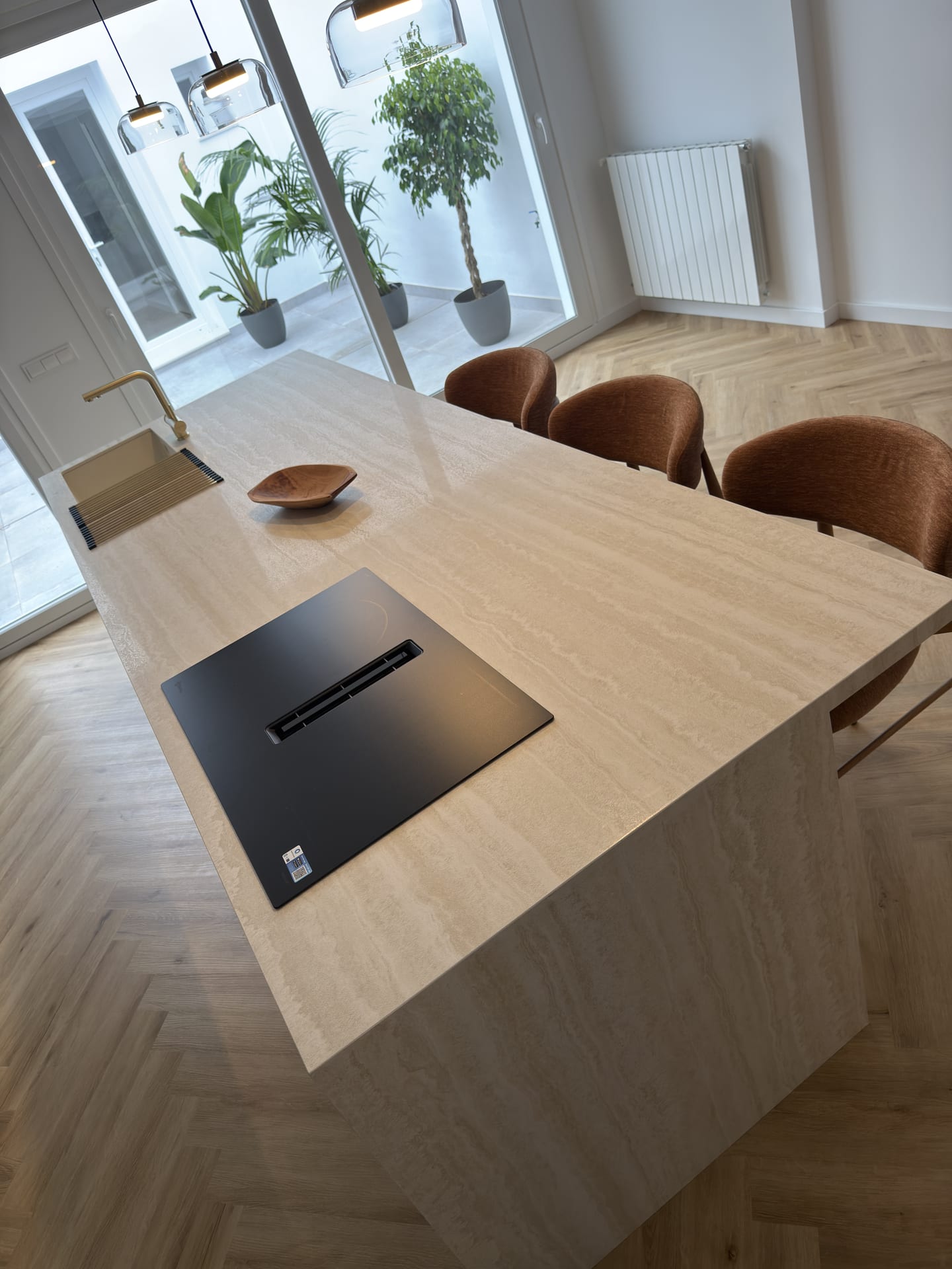 Encimera de porcelánico efecto travertino con placa de inducción y fregadero