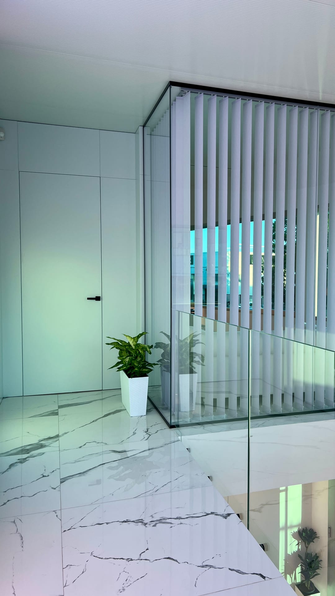 Planta superior con despachos acristalados y barandilla de vidrio