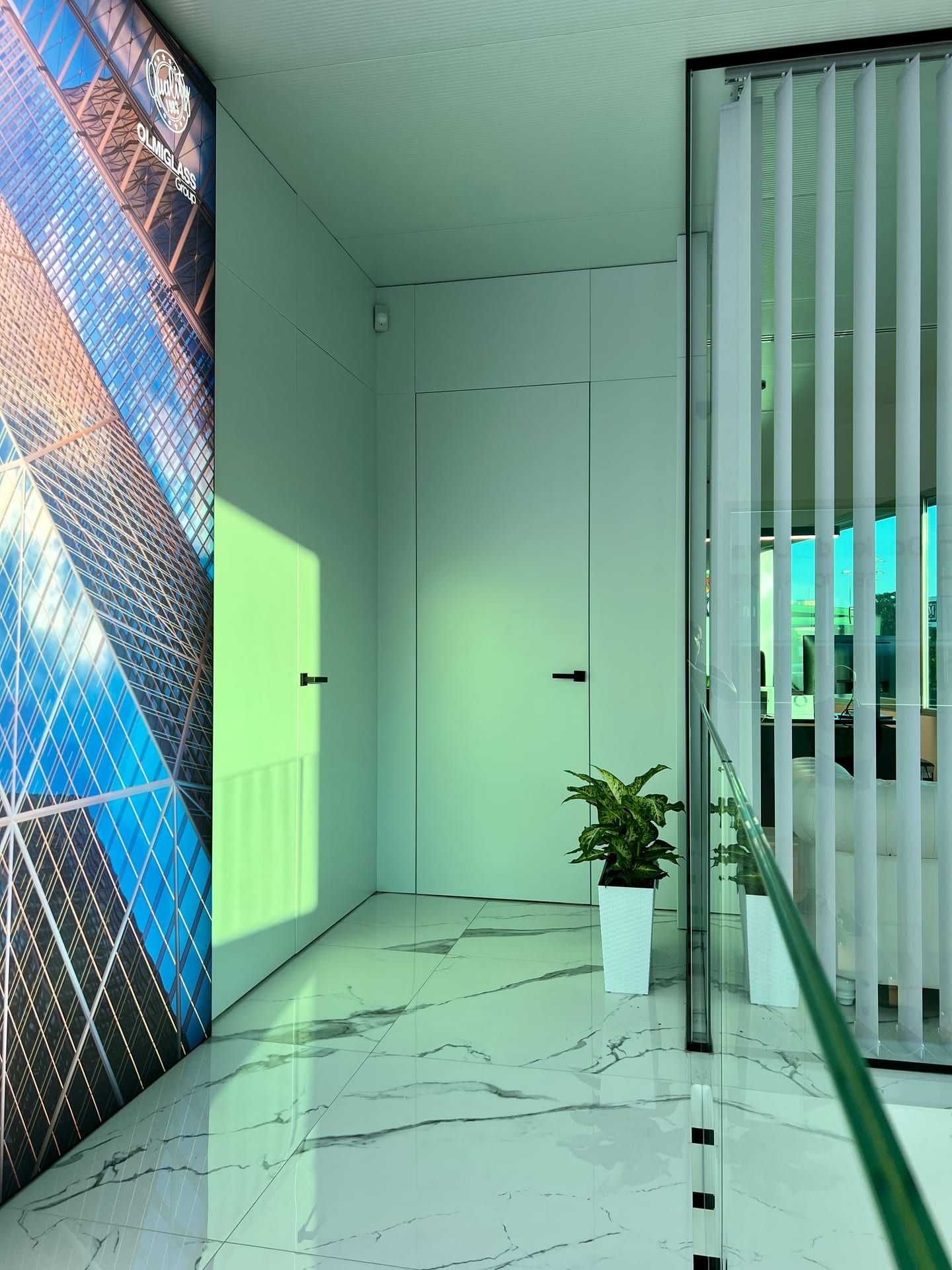 Recibidor con videowall y despacho acristalado